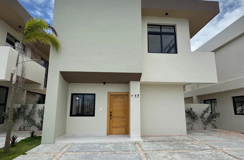 Casa moderna de dos plantas con puerta de madera en una comunidad residencial